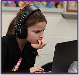 Girls wearing headphones focused on computer