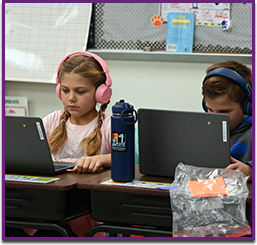 Two students focused on learning in the computer lab