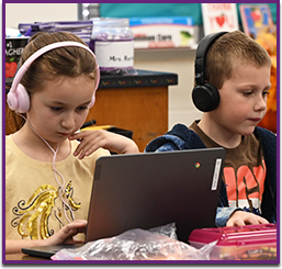 Two students wearing headphones in front of computers